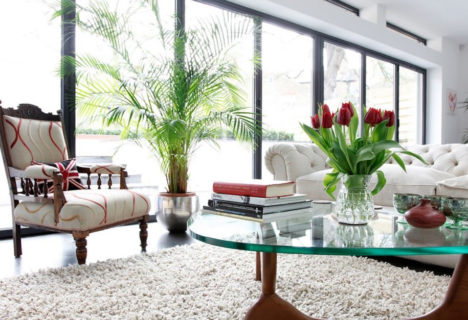 انرژی مثبت در خانه با استفاده گل های زیبای رز که روی میز جلو مبلی نشیمن کلاسیک قرار داده شده است